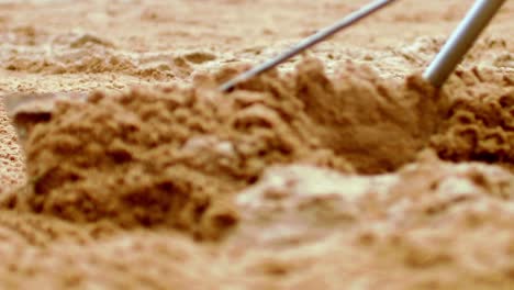 sand being moved to even the surface of the court