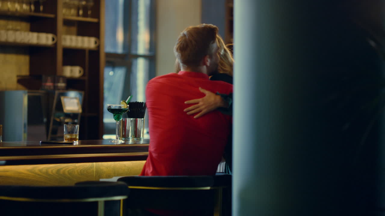 현대적인 술집에 뛰어드는 쾌활한 여성들. 술집 카운터 근처에서 친구들을 안아주는 소녀들.