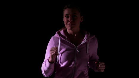 woman jogging against black background