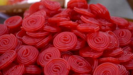 a pile of round red jelly candies on the market