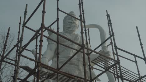 una estatua gigante con marco metálico delante de ella