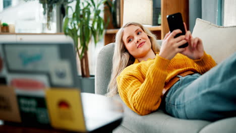 woman relaxing on couch using phone and laptop at home