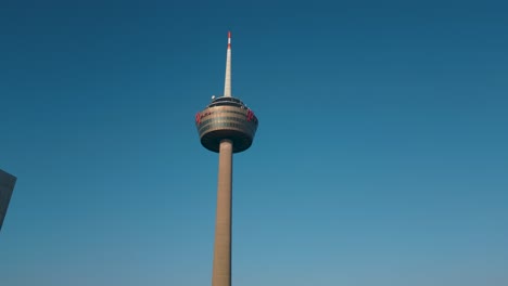 Toma-De-Dron-Ascendente-De-La-Torre-De-Televisión-De-Colonia-Durante-El-Día---Vista-Aérea-De-Dron:-Impresionantes-Imágenes-De-Un-Hito-Icónico-Con-Cielo-Azul---Alemania,-Köln-2023