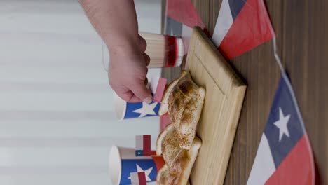 fiestas patrias chile poniendo una bandera chilena en empanada y banderas chilenas y terremoto bebida nacional vertical