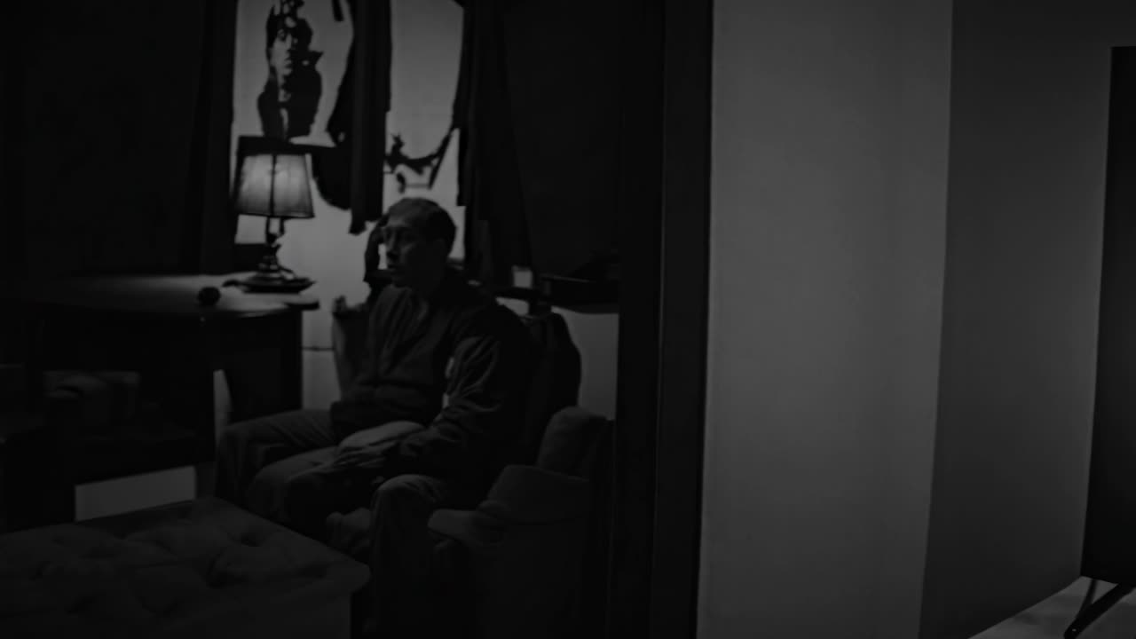 habitación negra y blanca con televisión y hombre