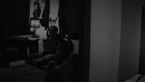 habitación negra y blanca con televisión y hombre