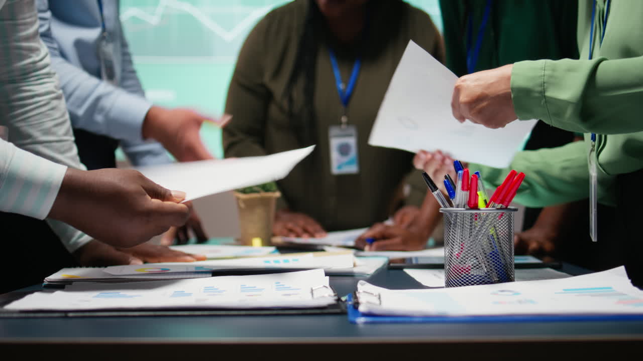 After hours briefing with multiethnic group gathering in a strategy room
