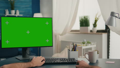 Pov-of-man-hands-sitting-on-office-desk-using-computer-with-mock-up-green-screen-chroma-key