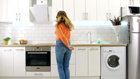 young happy woman dancing in kitchen and having some fun