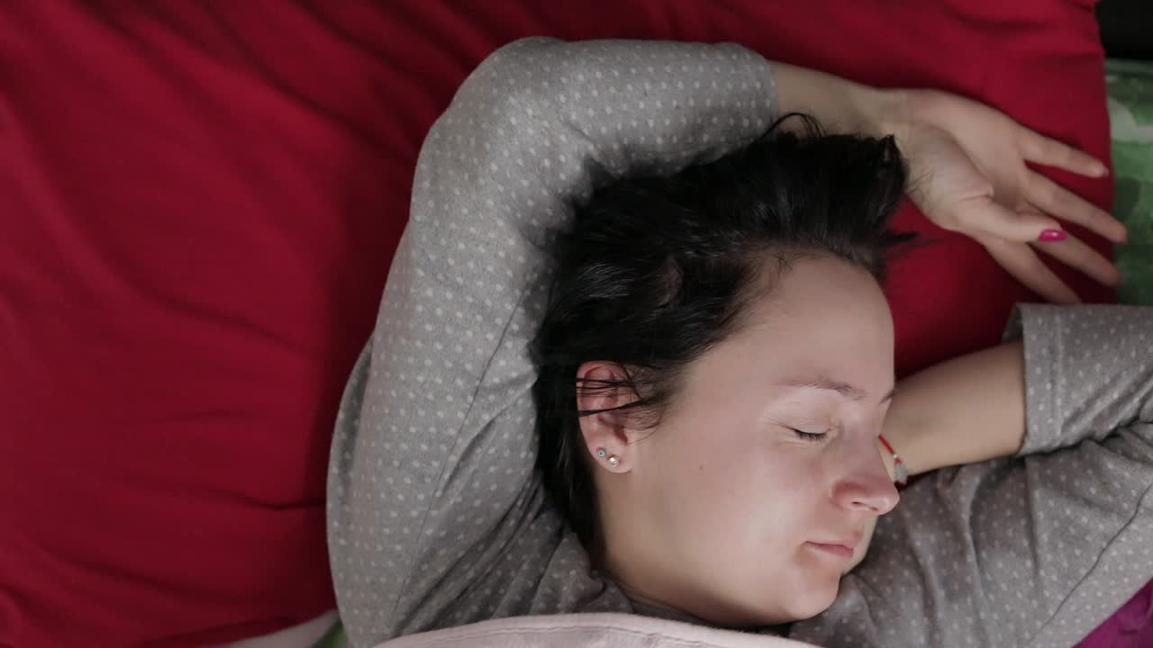 잠든 젊은 여자는 아침에 깨어나고 싶지 않습니다.