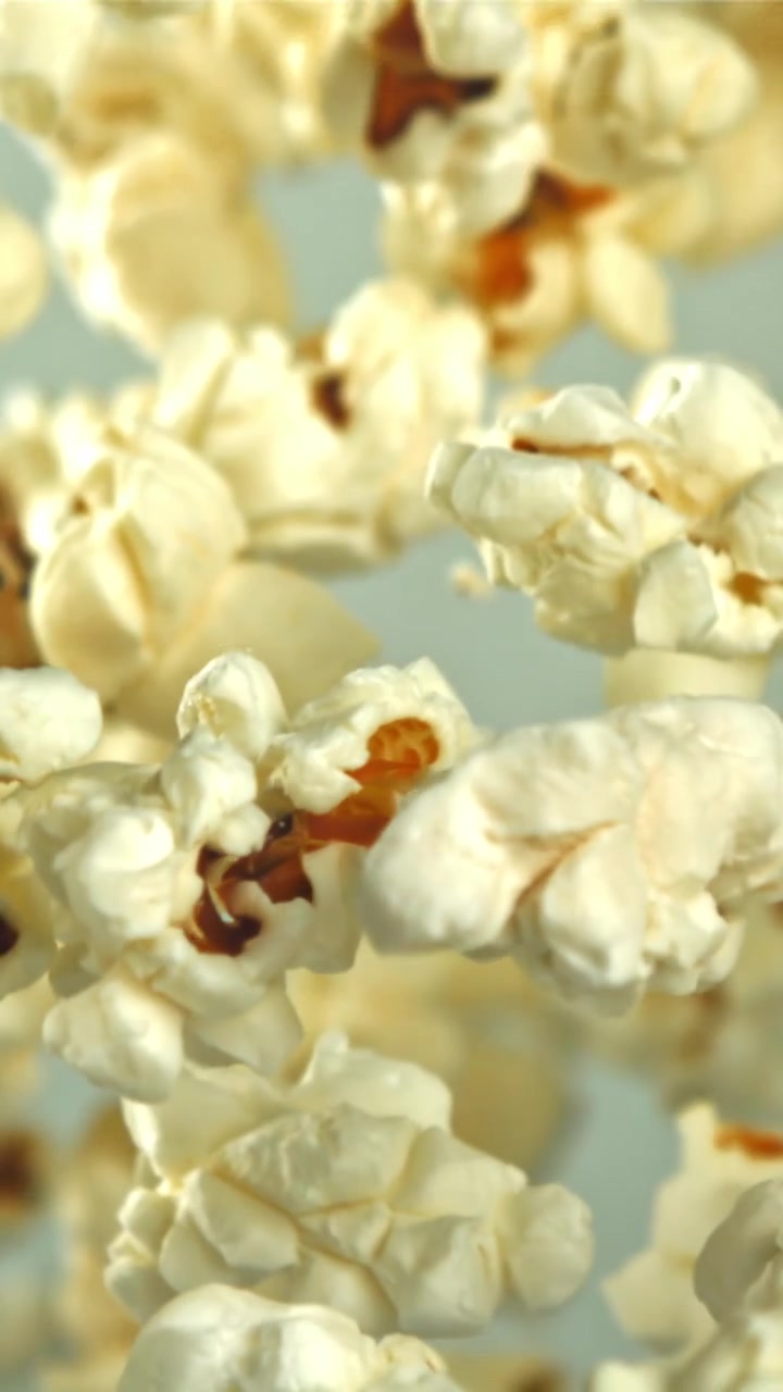 Deliziosi pezzi di popcorn che fluttuano verso l'alto a movimento rallentato