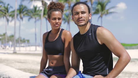 athletic couple sitting and resting after sports