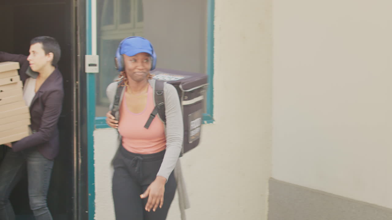 Food delivery person delivering pizza to customer