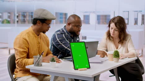 Clients-discussing-with-the-contractor-next-to-green-screen-on-tablet