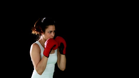 fit brunette punching with gloved fists