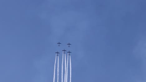 muestra formación aérea volando con rastros de humo