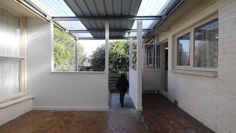 hombre caminando por la escalera desde el área del patio hasta el área del patio trasero