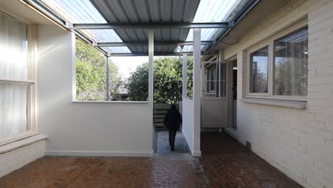 man walking down stair case from patio area into backyard area