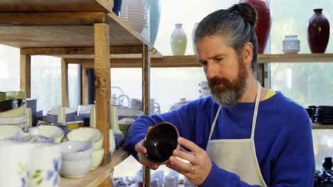 Male-potter-examining-a-earthenware-bowl