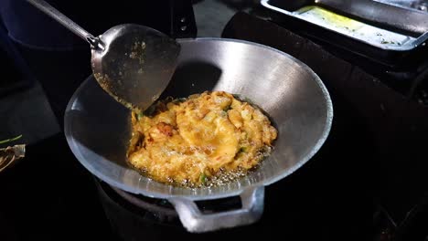 cocinando una tortilla en un puesto de comida callejera