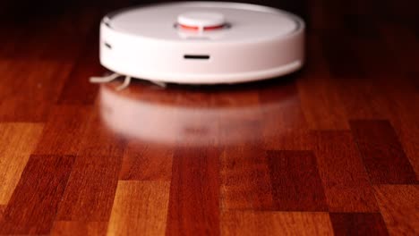 smart robot vacuum cleaner with lidar on wood floor. robot vacuum cleaner performs automatic cleaning of the apartment. slow motion 100 fps. ungraded video