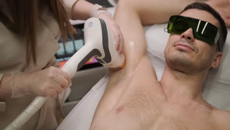 man armpit area during procedure of laser hair removal in modern cosmetology clinic. concept of man beauty, cosmetology, epilation