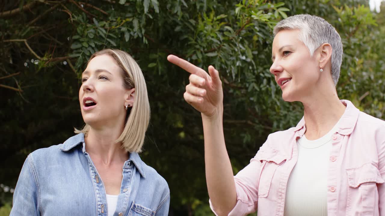 Twee vrouwen in de tuin merken iets buiten beeld op en maken wijzende gebaren om de grootte aan te geven voor de planning.