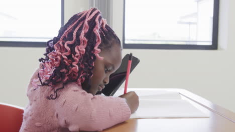 in classroom, african american girl writing in notebook, concentrating, at school, copy space