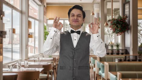 happy indian waiter showing okay sign