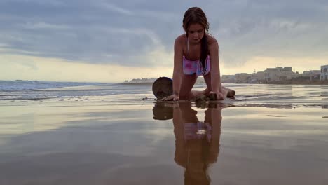 Low-angle-of-adorable-caucasian-little-girl-playing-with-bucket-and-sand-on-beach