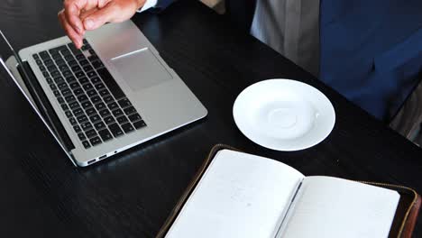 hombre de negocios trabajando en una computadora portátil mientras toma café