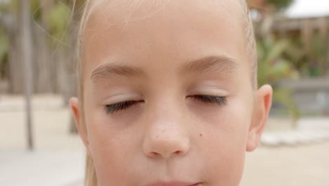 Portrait-of-happy-caucasian-girl-looking-at-camera-over-beach-house