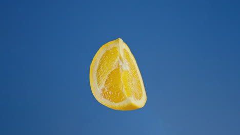 close up of orange wedge on a blue screen, loopable chroma key