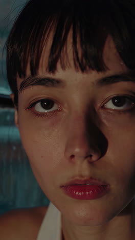 woman looking out of a rainy window