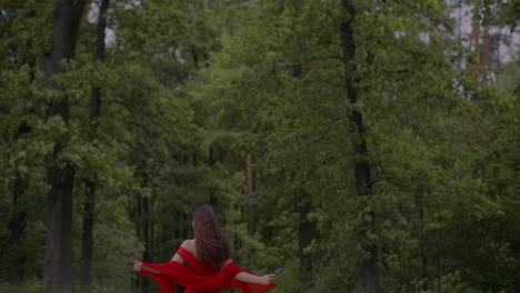 woman in red dress posing in forest