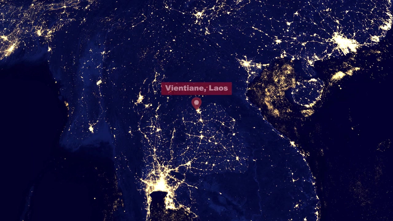 Animazione digitale zooma dallo spazio esterno alle luci illuminate della città di Vientiane, Laos, di notte.