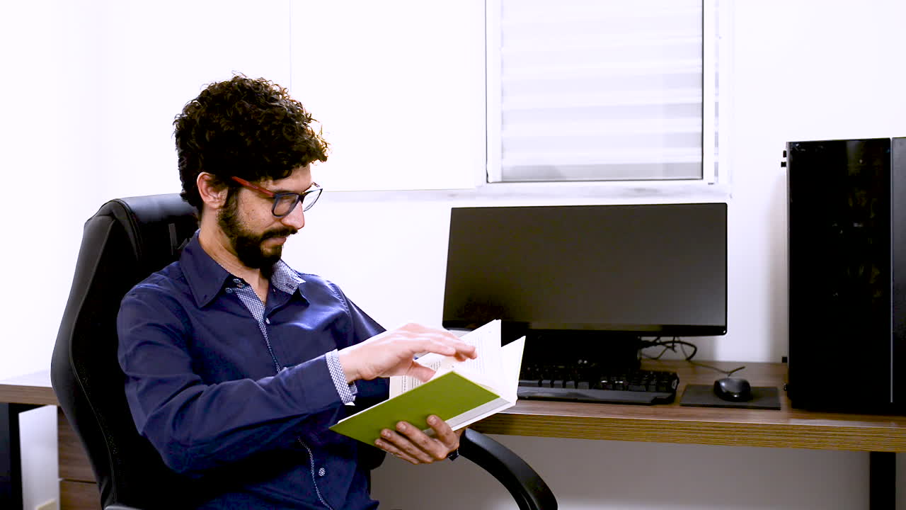 leyendo un libro verde en la oficina en casa modelo masculino