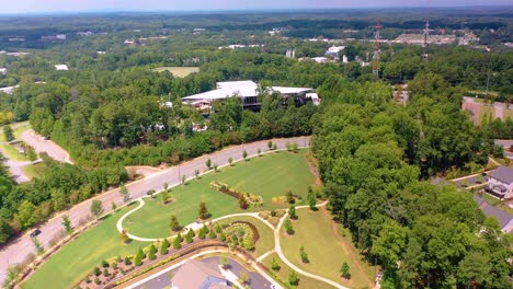 un dron aéreo se inclinó hacia arriba desde un pequeño vecindario para contemplar la ciudad de alpharetta, ga y el anfiteatro del banco ameris
