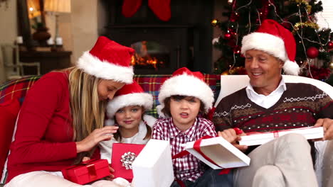 Glückliche-Familie-öffnet-Weihnachtsgeschenke