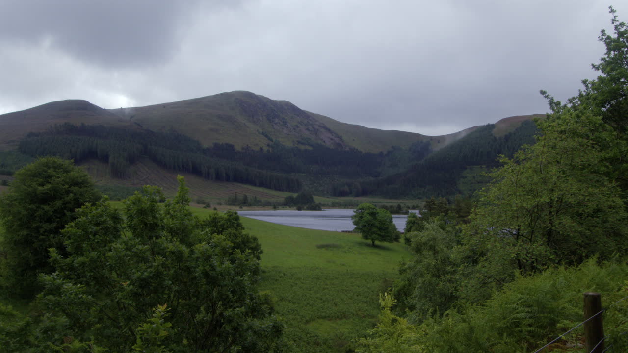 wide shot through the trees of Cogra Moss lake with gavel fell and middle fell in background