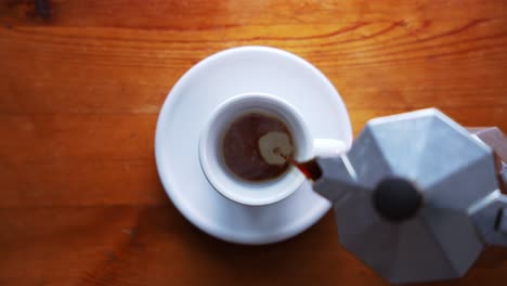 la máquina de espresso de la vieja escuela italiana está llenando la taza con café marrón fresco y caliente