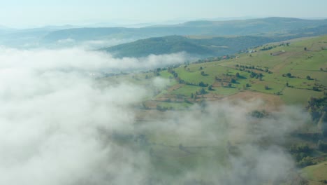 toma aérea rodando de regreso a través de un paisaje pastoral cubierto de nubes