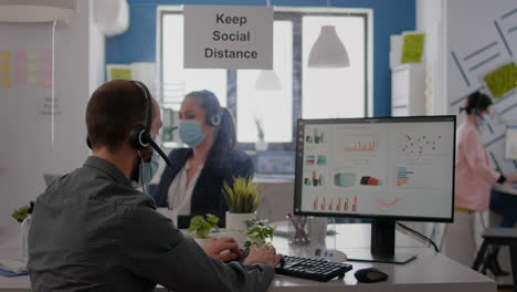 Close-up-of-businessman-talking-with-coworker-into-microphone-about-business-meeting