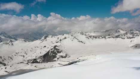 air flight through mountain clouds over beautiful snow-capped peaks of mountains and glaciers.