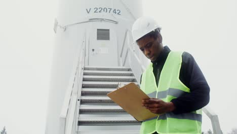 worker inspecting wind turbine