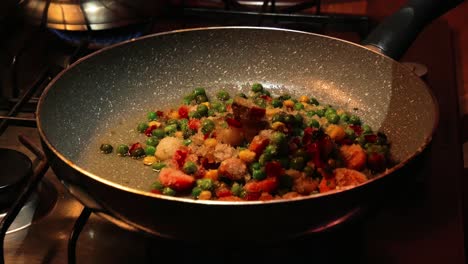 Pouring-frozen-vegetables-into-hot-pan-with-hot-oil