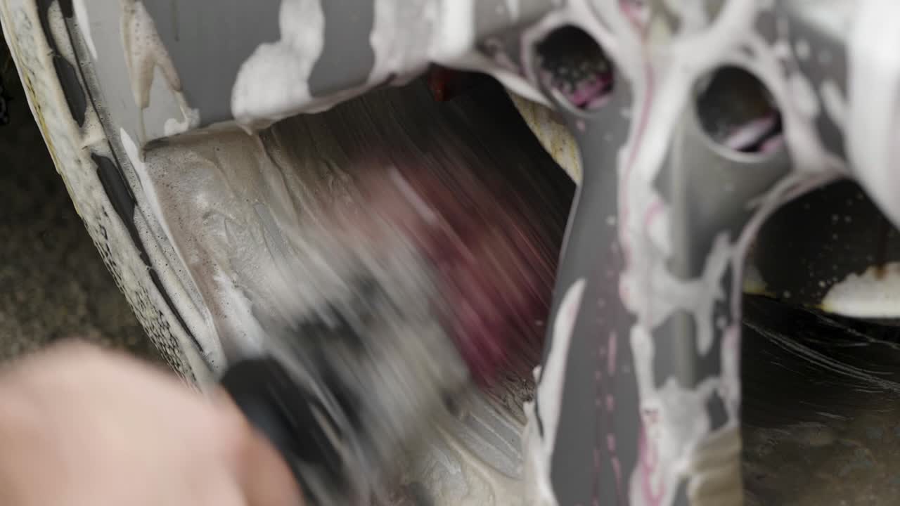 검은 차의 은색 바 ⁇ 를 청소하고 있습니다.