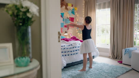 happy teenage girl dancing in bedroom wearing ballet tutu having fun practicing dance moves at home