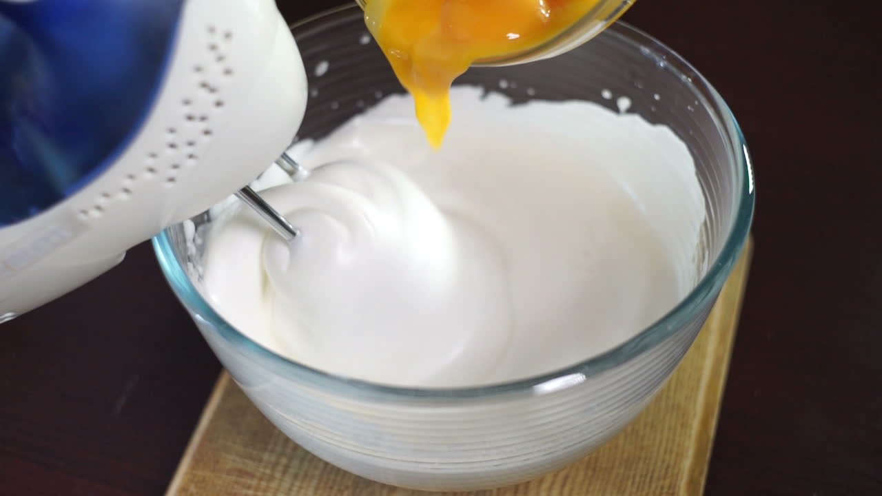 Whipping cream with electric mixer. Add yolk while mixing cream in glass bowl