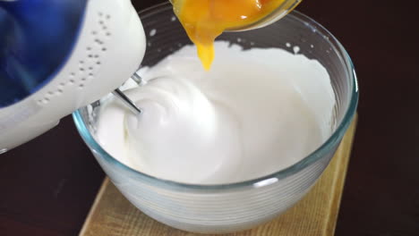 Whipping-cream-with-electric-mixer.-Add-yolk-while-mixing-cream-in-glass-bowl